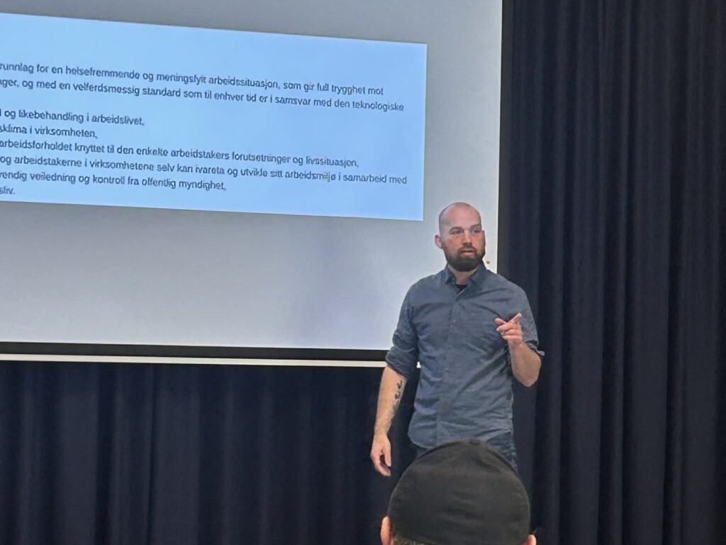 Klaus Lintho står foran et lysbilde med formålsparagrafen i arbeidsmiljøloven og snakker til kursdeltakere.